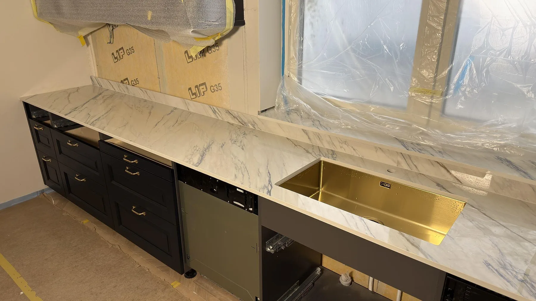 Köksbänkskiva i polerad Dekton Trance keramik med synlig diskho och stänkskydd runt fönstret i Åkersberga.