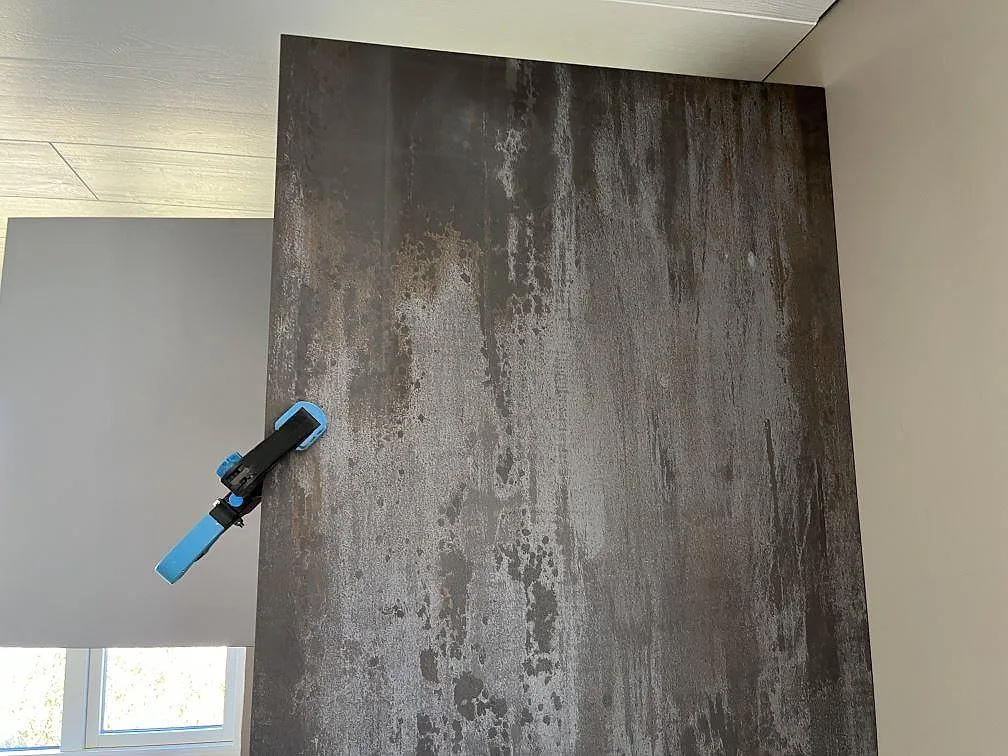 Heltäckande stänkvägg i mörk Dekton Trilium med monterad köksblandare i ett kök i Åstorp.