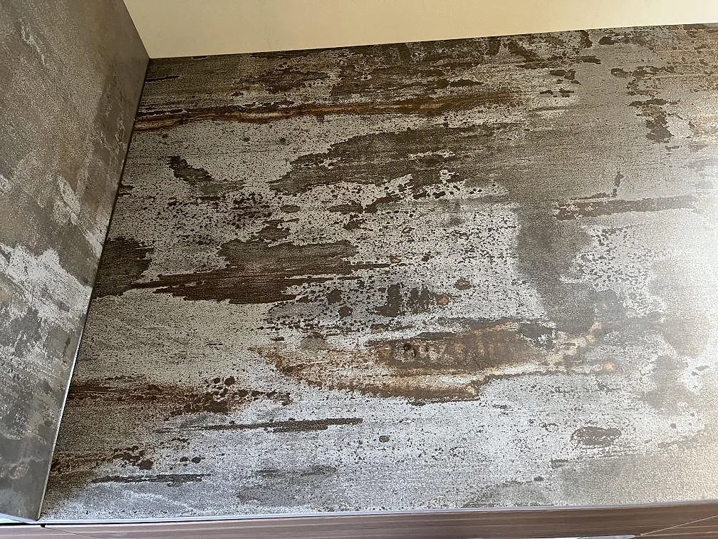Närbild på den spräckliga, matta ytan hos en Dekton Trilium stänkvägg i ett kök i Åstorp.