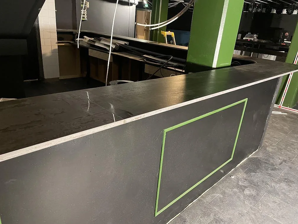 Bardisk i matt Dekton Trilium keramik med slätad svart front och gröna detaljer i en bar i Borås.
