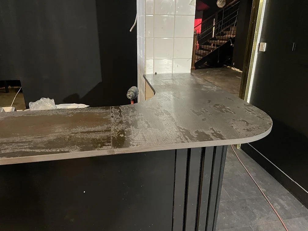 Rundad bardiskskiva i matt Dekton Trilium keramik med mörk yta och väggkakel i Borås.