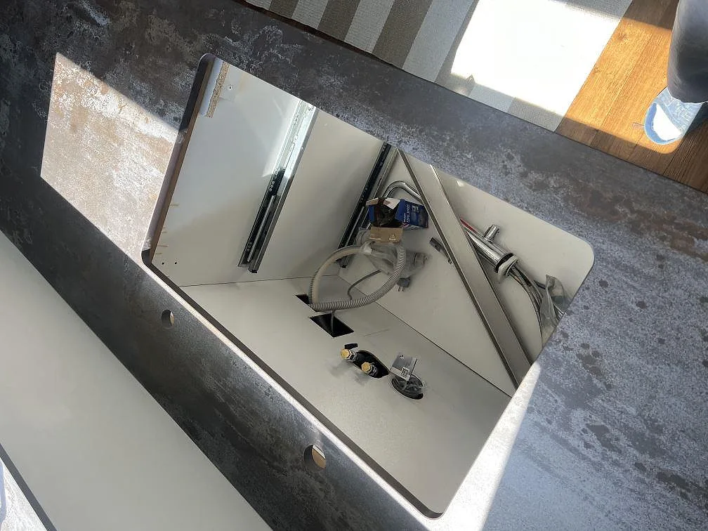 Närbild på diskhoöppning och blandarhål i matt Dekton Trilium keramik på köksö i Hasslö.