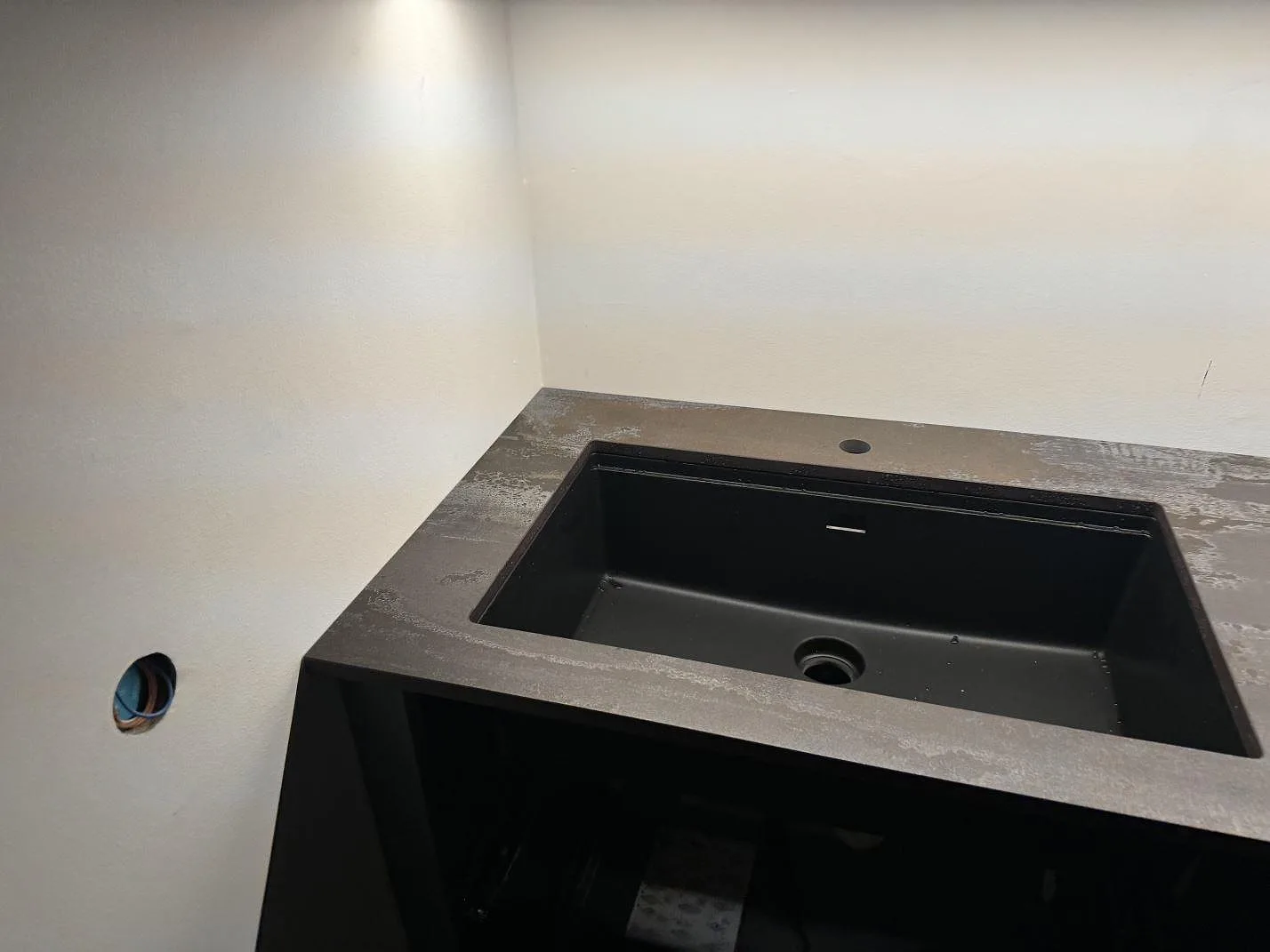 Diskbänk i matt Dekton Trilium med svart diskho, blandarhål och mörk keramisk ådring i kök i Helsingborg.