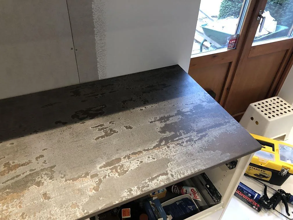 Köksbänkskiva i Dekton Trilium på en rad vita köksskåp med fronter, matt grafitgrå yta, kök i Jonstorp.