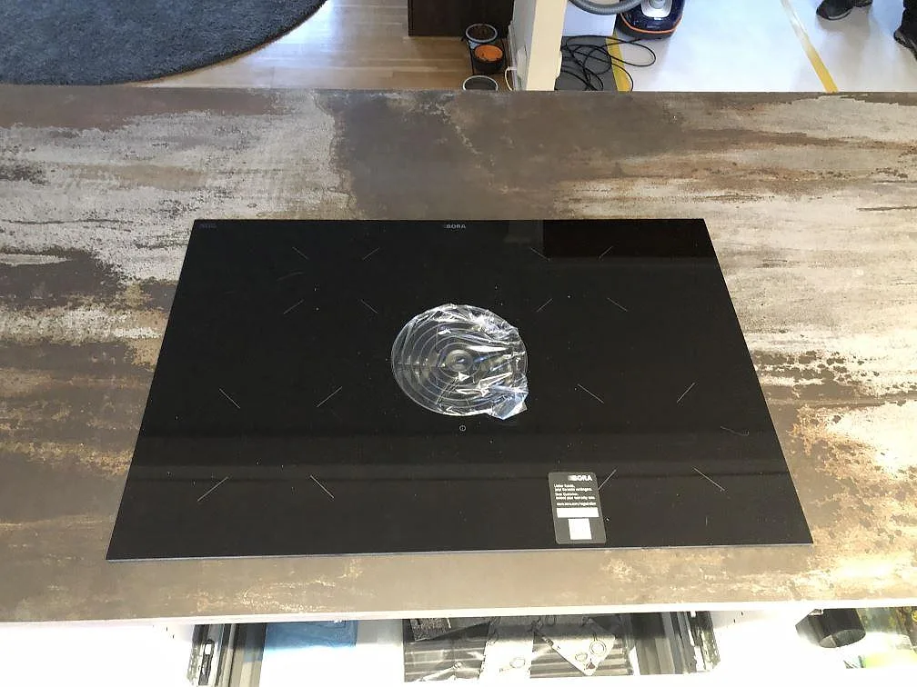Fönsterbänk i Dekton Trilium under ett fönster, matt grafitgrå sten med köksbänk i förgrunden, kök i Jonstorp.