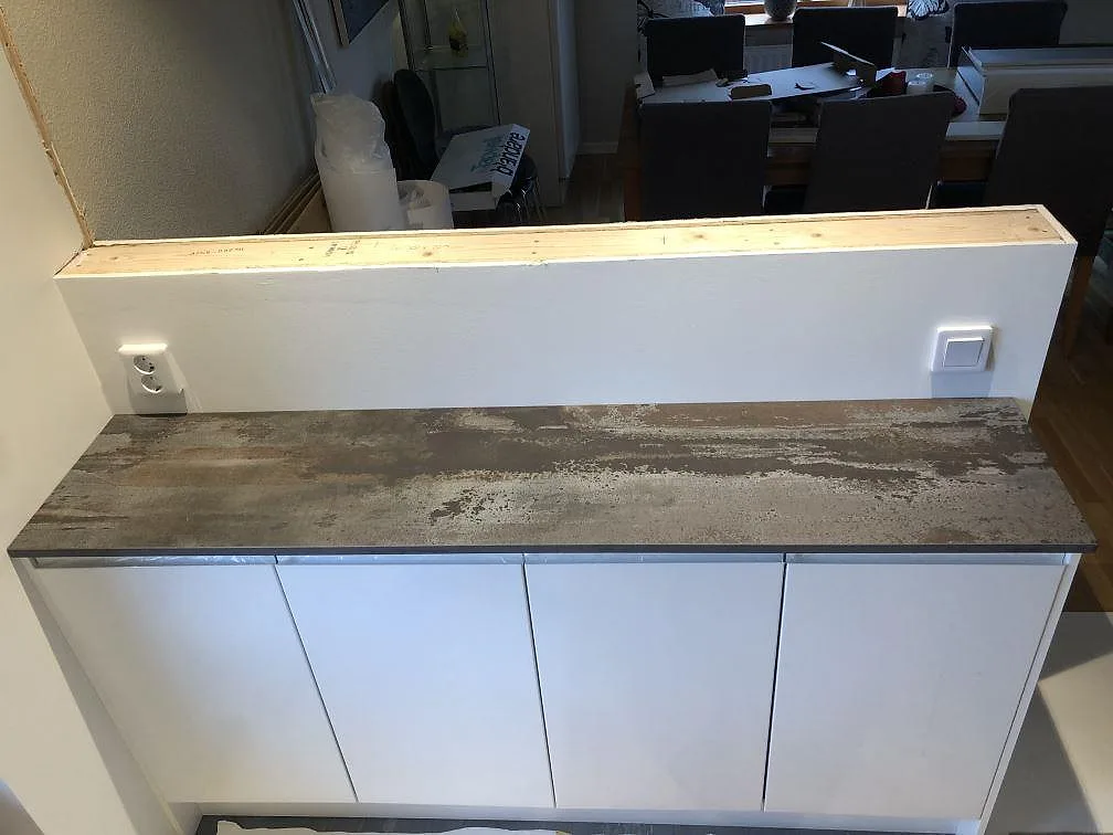 Köksö i Dekton Trilium sedd snett uppifrån med infälld BORA-induktionshäll i bänkskivan, kök i Jonstorp.