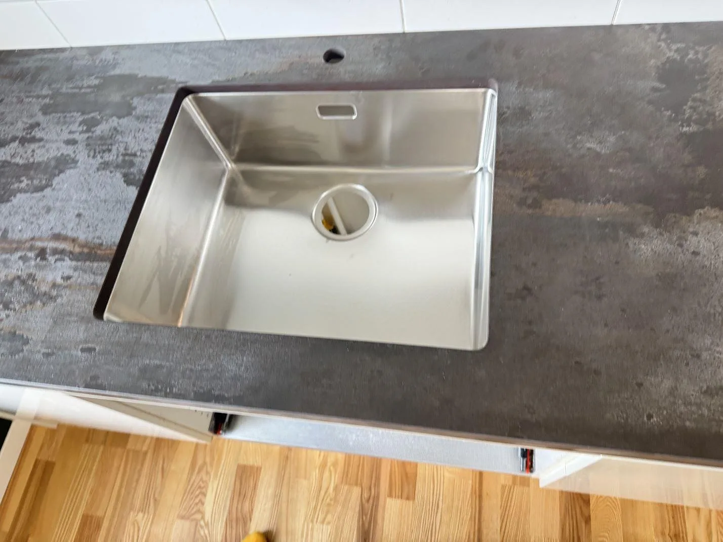 Detalj av matt keramisk Dekton Trilium med rostfri diskho monterad i bänkskivan i Malmö.