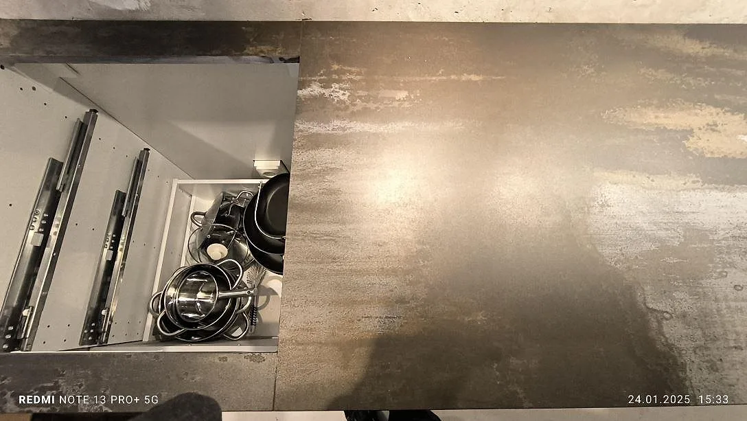 Detalj av matt Dekton Trilium i keramik vid öppen lådstomme under montering i kök i Solna.