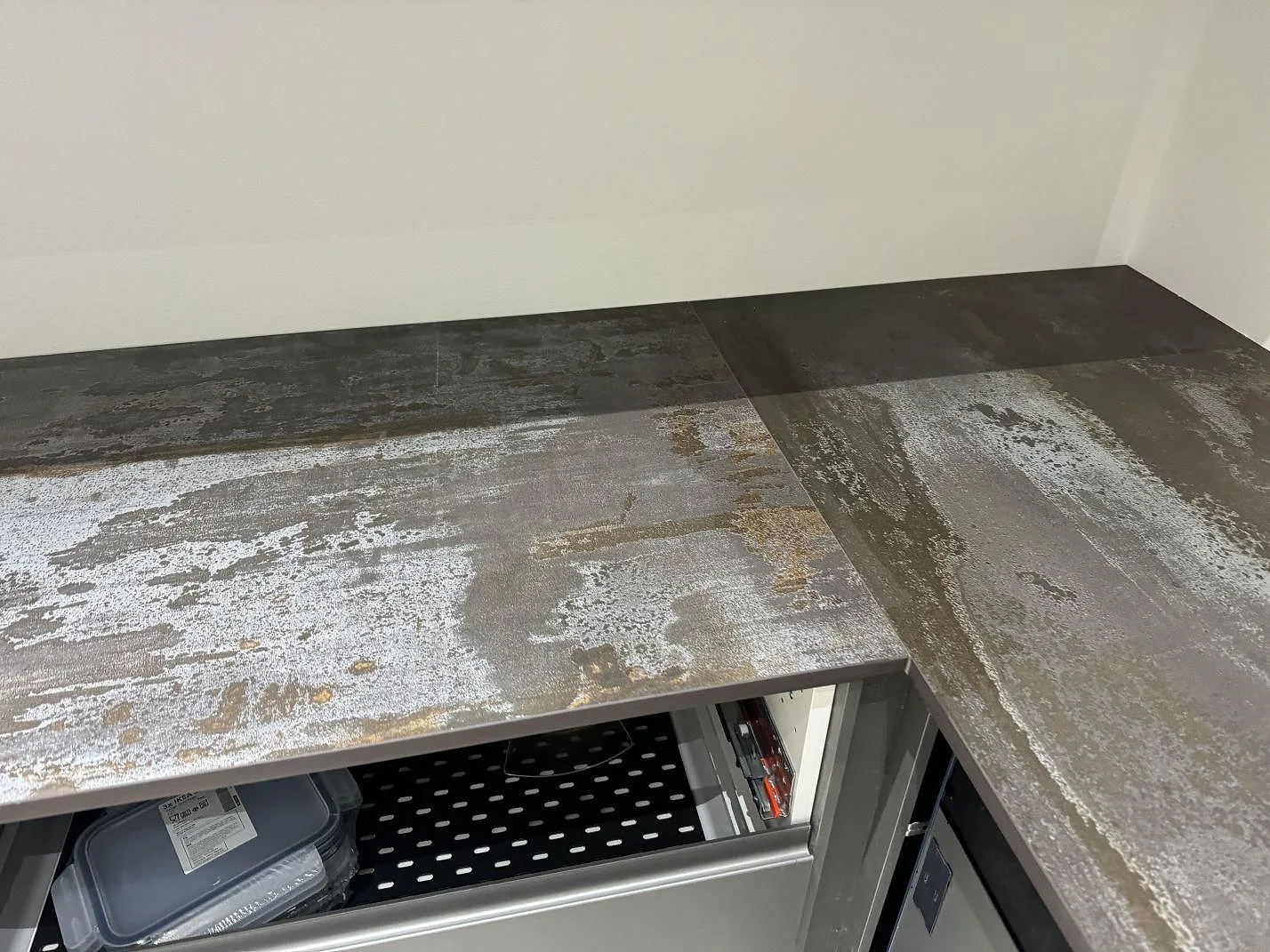L-formad köksbänkskiva i matt Dekton Trilium keramik monterad på grå stommar i Torslanda.