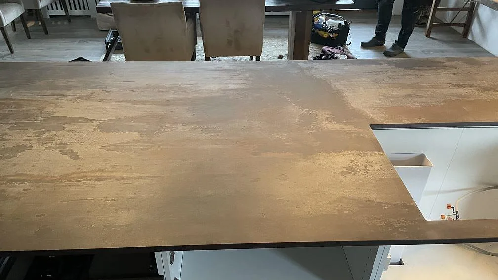 Närbild av den rostbruna keramiska bänkskivan Dekton Trilium med urtag i köksön i Vedbæk.