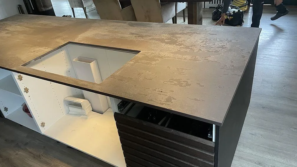 Matt köksö i Dekton Trilium med förberett rektangulärt urtag och öppna köksstommar under montering i Vedbæk.