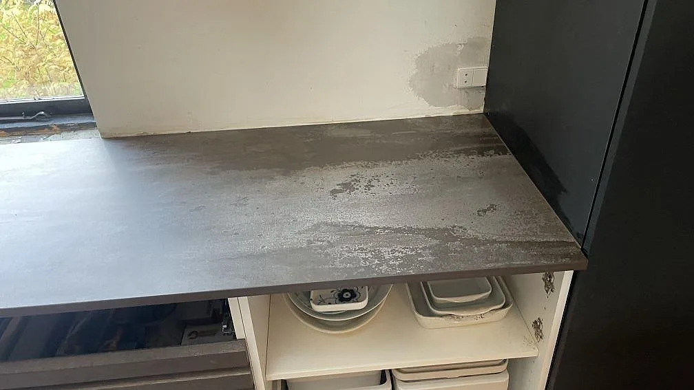 Rak väggsektion med bänkskiva i Dekton Trilium, matt keramik med industriellt mönster i Vedbæk.