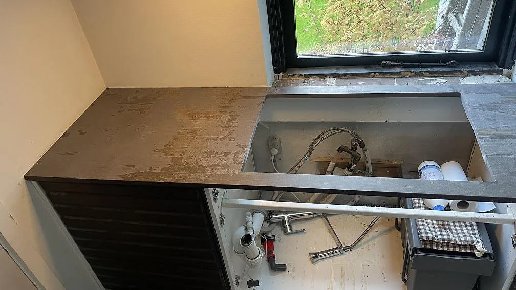 Väggbänk i matt Dekton Trilium med stort förberett urtag vid fönster och synlig installation i Vedbæk.