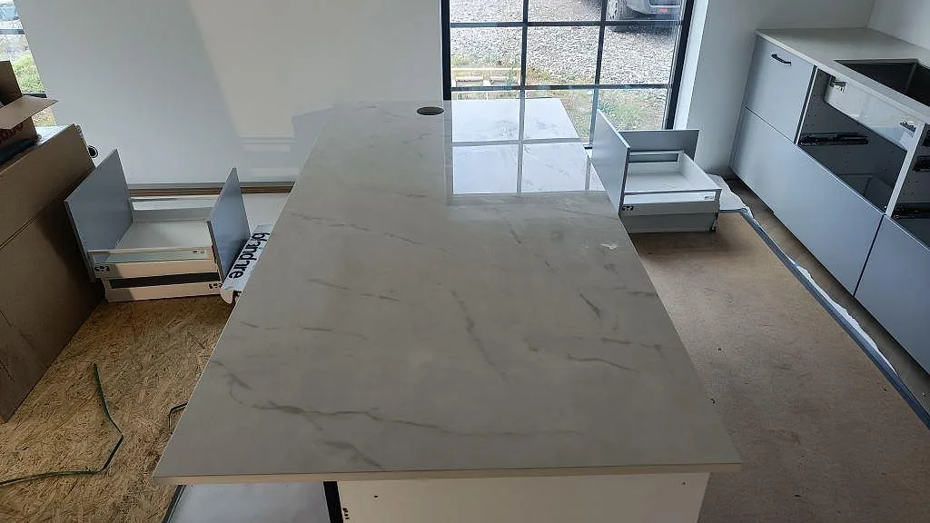 Köksö i polerad Dekton Tundra med håltagning för köksblandare och spegelblank yta i Asmundtorp.