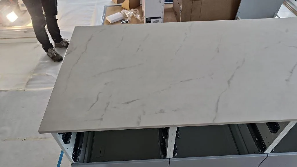 Köksö i Dekton Tundra under montering med öppna lådstommar i ett kök i Asmundtorp.