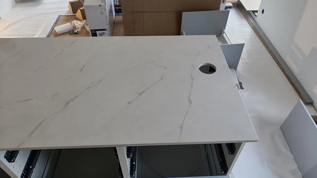 Köksö i vit Dekton Tundra med diskret ådring och håltagning för blandare i ett kök i Asmundtorp.