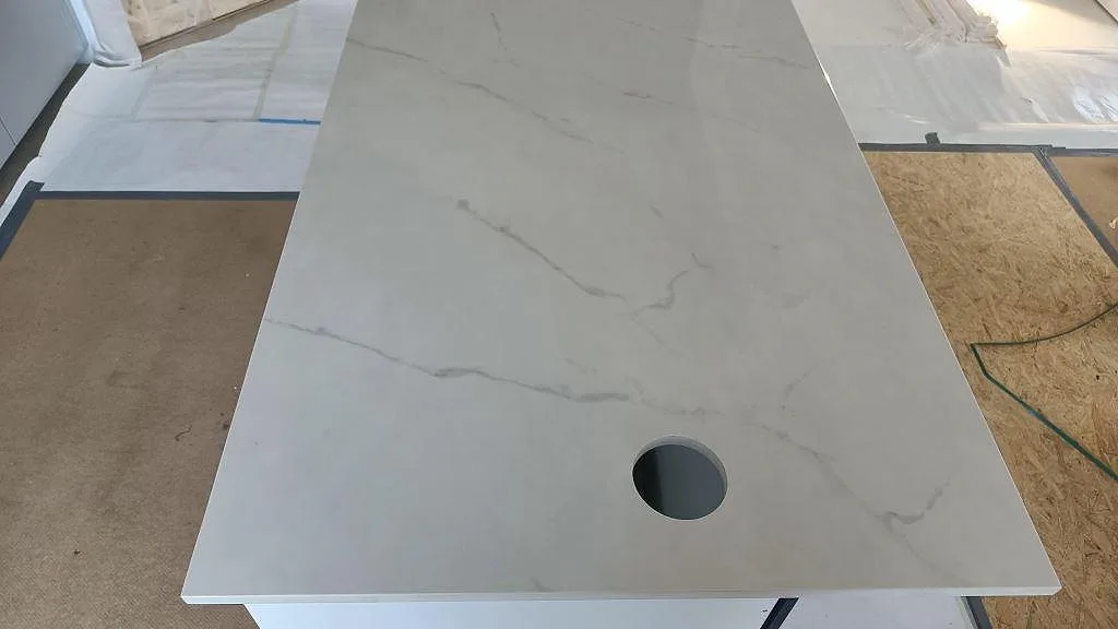 Köksö i Dekton Tundra ovanifrån med synlig grå ådring i ett kök under montering i Asmundtorp.