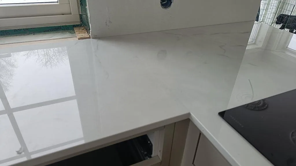 Närbild på den polerade vita ytan i Dekton Tundra med fin grå ådring i ett kök i Borås.