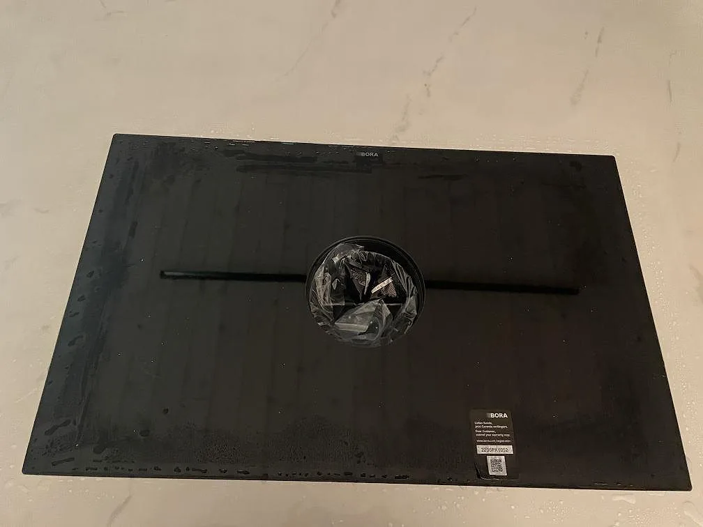 BORA-häll nedsänkt i den ljusa Dekton Tundra-bänkskivan, polerad keramikyta, i ett kök i Rydebäck.