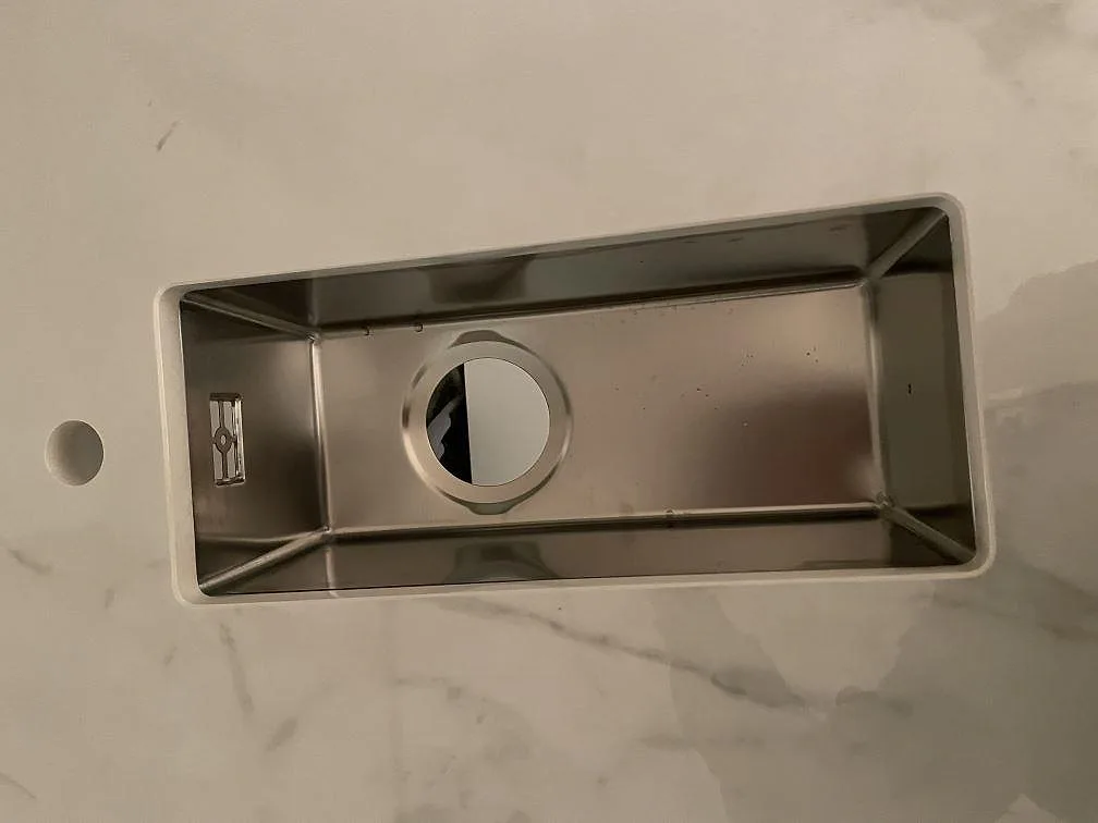 Smalare underlimmad rostfri bihandho i den gräddvita Dekton Tundra-bänkskivan i ett kök i Rydebäck.