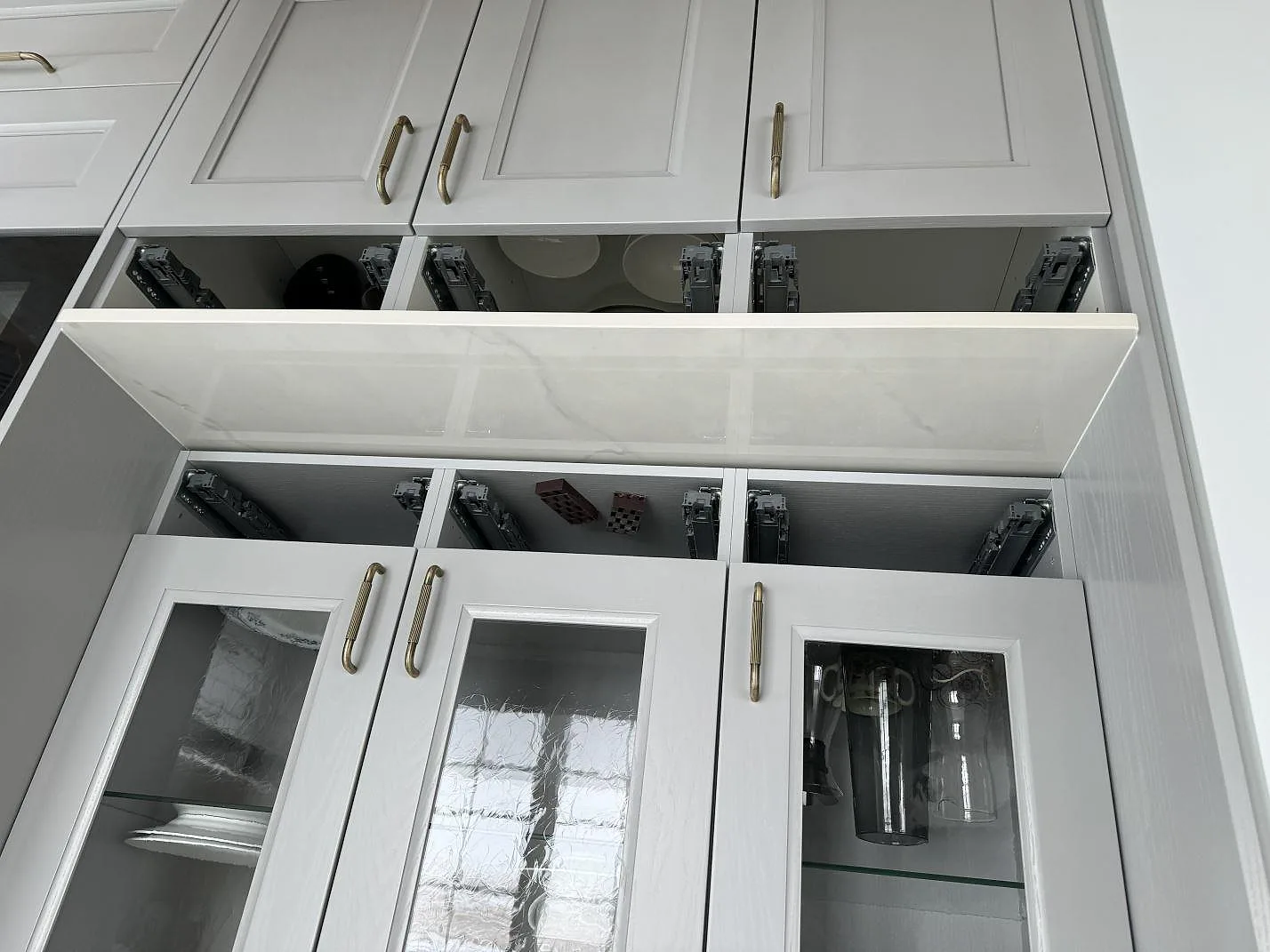 Detalj av polerat stänkskydd och bänkskiva i Dekton Tundra 19 framför grå köksskåp i Stråvalla.