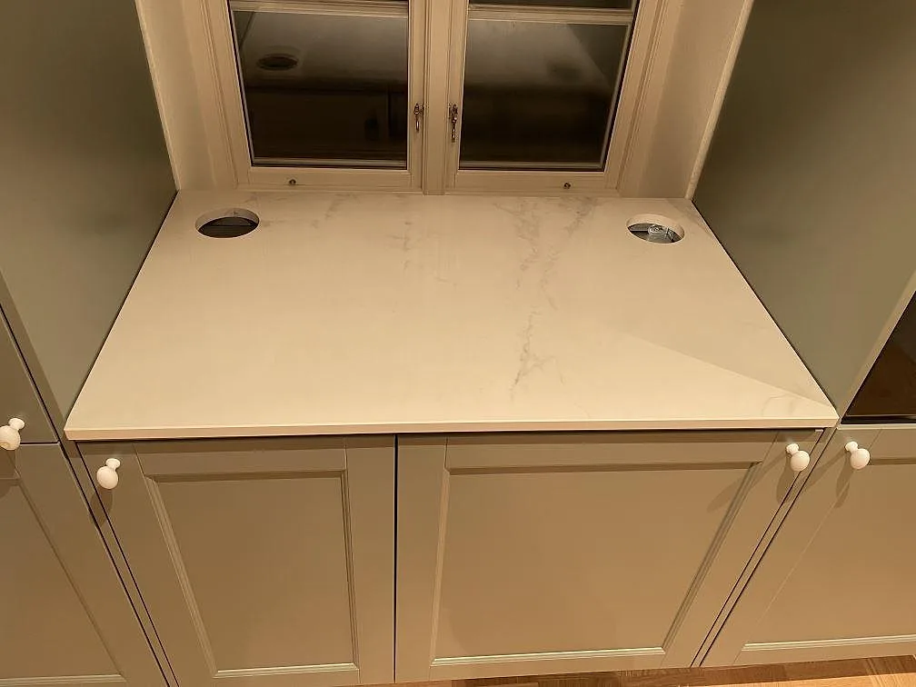 Dekton Tundra bänkskiva under överskåp med glasluckor i ett kök i Trelleborg.