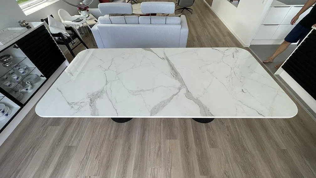 Rektangulär bordsskiva i polerad Dekton Vigil med grå ådring, placerad i ett möblerat rum i Ishøj.