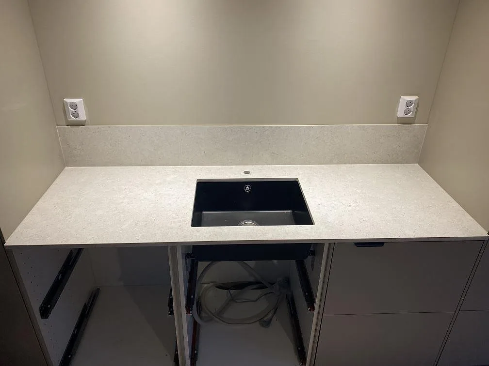 Rak köksbänkskiva i matt Dekton VK01 Nebbia med svart diskho och låg stänkkant i samma keramik i Älmhult.