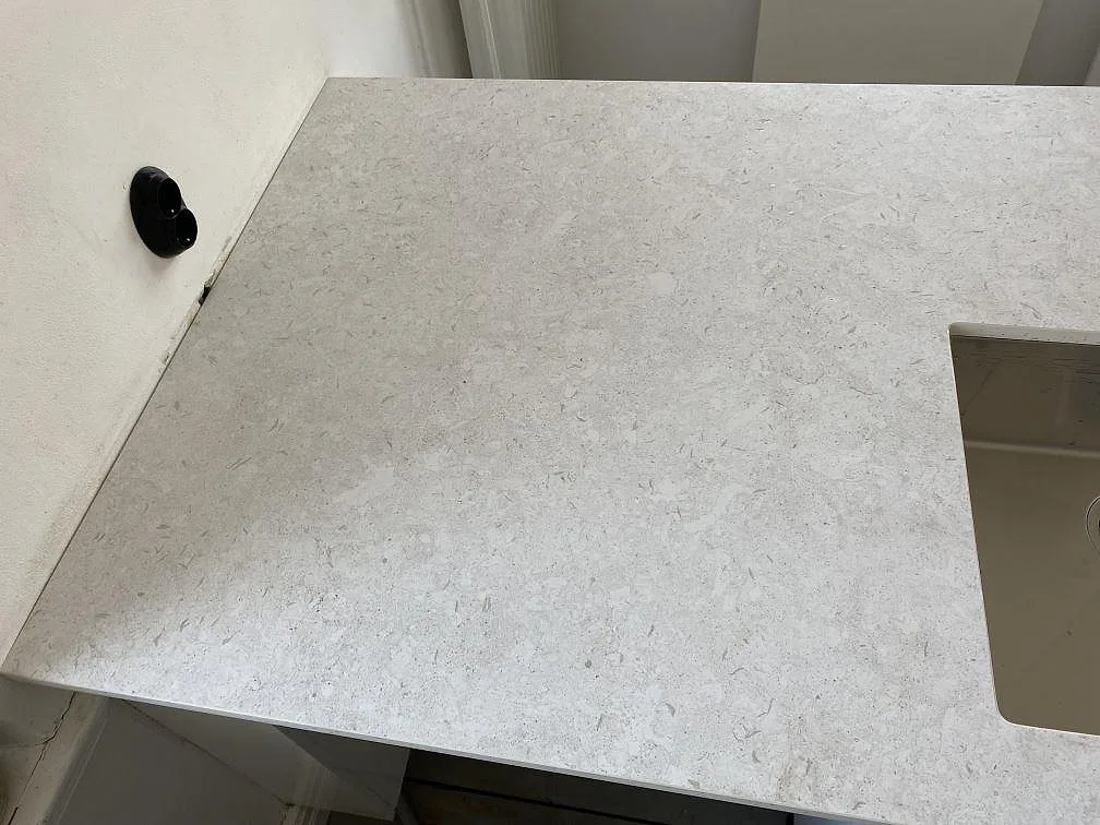 Närbild på den matta ytan i Dekton VK01 Nebbia med ljus ådring och utskuren öppning i kök i Eslöv.