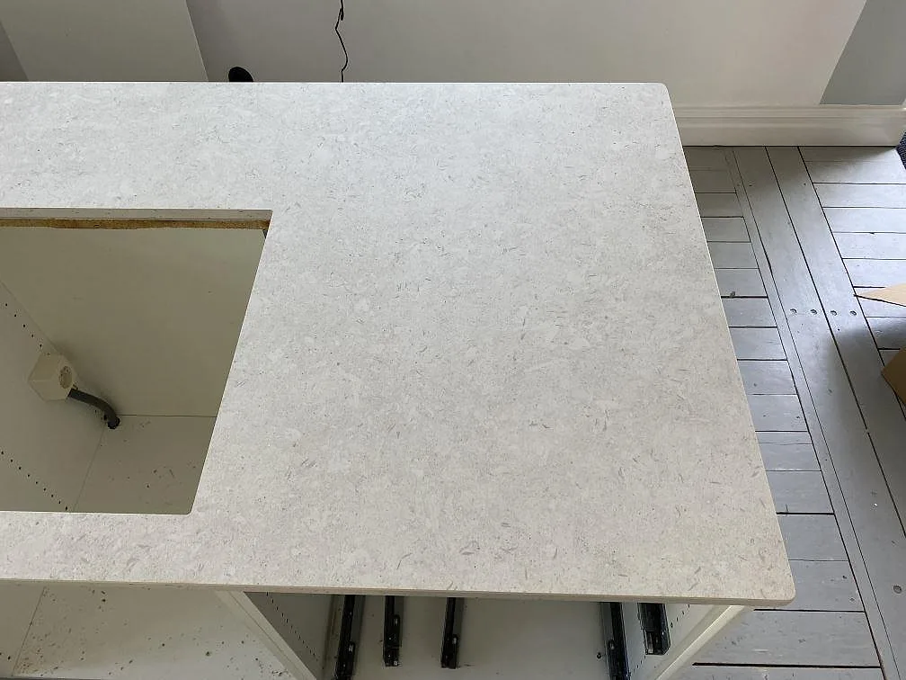 Närbild på ljus matt Dekton VK01 Nebbia yta vid ett större ursåg i köksbänkskivan i Eslöv.