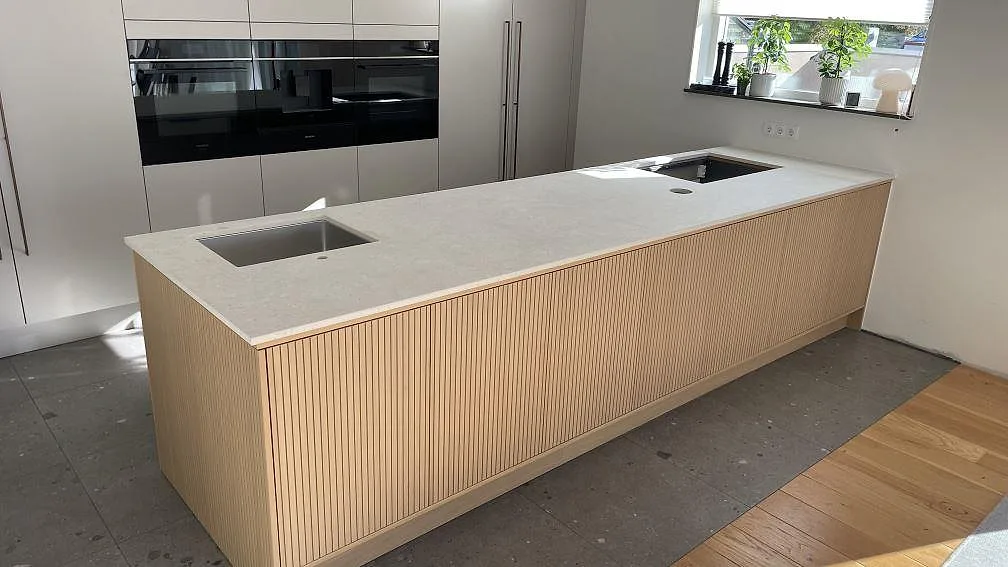Köksbänkskiva i matt 20 mm Dekton VK01 Nebbia med rostfri diskho och hällöppning i ett kök i Helsingborg.