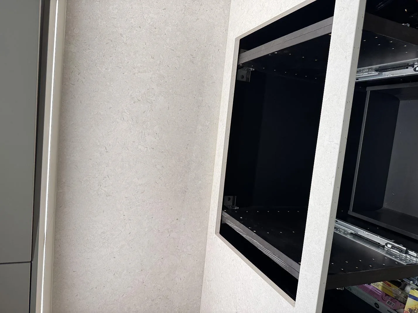 Närbild av stänkskydd och bänkskiva i matt Dekton VK01 Nebbia keramik vid öppna köksstommar i Höllviken.
