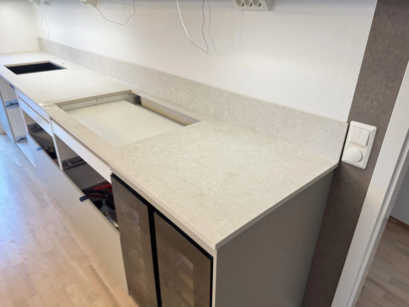 Lång köksbänkskiva i matt Dekton VK01 Nebbia med 8 mm stänkskydd och urtagning i kök i Lindome.