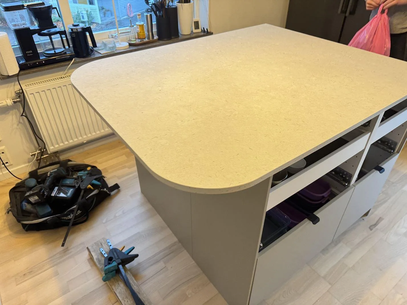 Stor köksö i matt Dekton VK01 Nebbia under montering, med öppen stomme och ljus yta i Lindome.