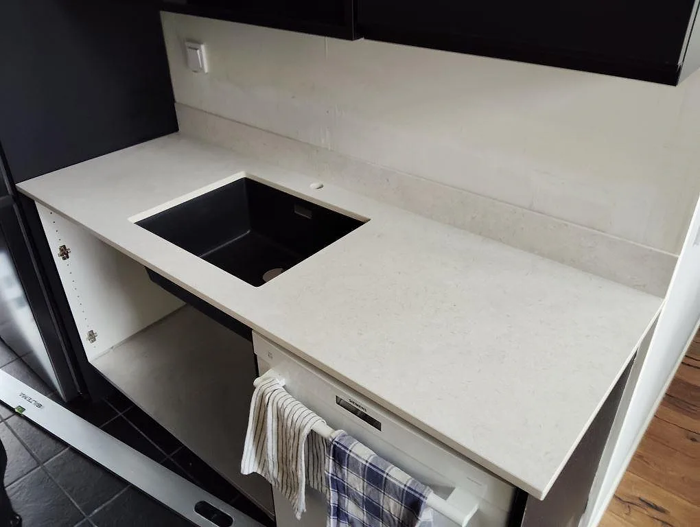 Matt Dekton VK01 Nebbia köksbänkskiva med utskuren diskhoöppning och låg stänkkant i ett kök i Oxelösund.
