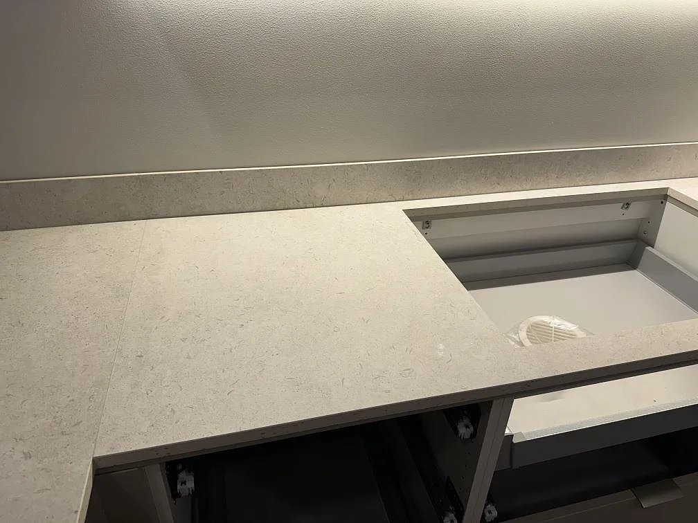 Köksbänk i matt Dekton VK01 Nebbia med rektangulärt urtag och 8 mm stänkskydd under montering i Trelleborg.