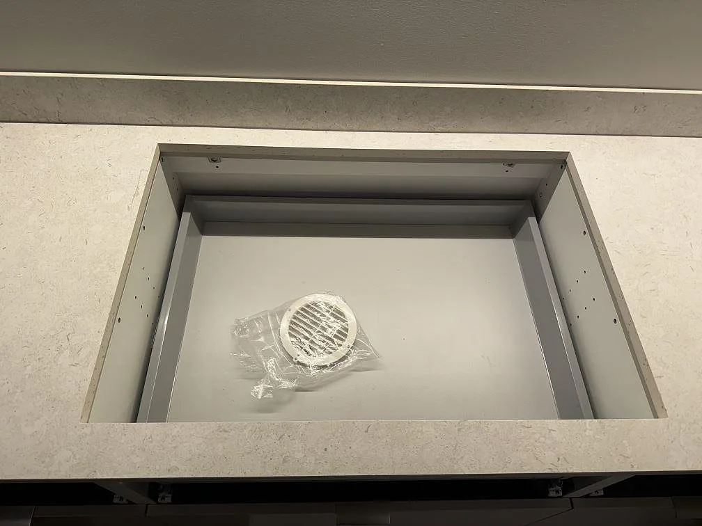 Närbild på rektangulärt urtag i köksbänkskiva av matt Dekton VK01 Nebbia med stänkskydd i Trelleborg.