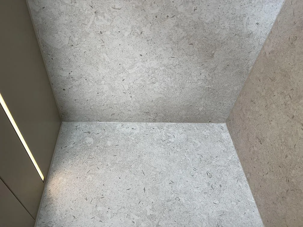 Närbild på ljusgrå Dekton VK01 Nebbia keramik med matchande bänkskiva och väggparti i Värnamo.
