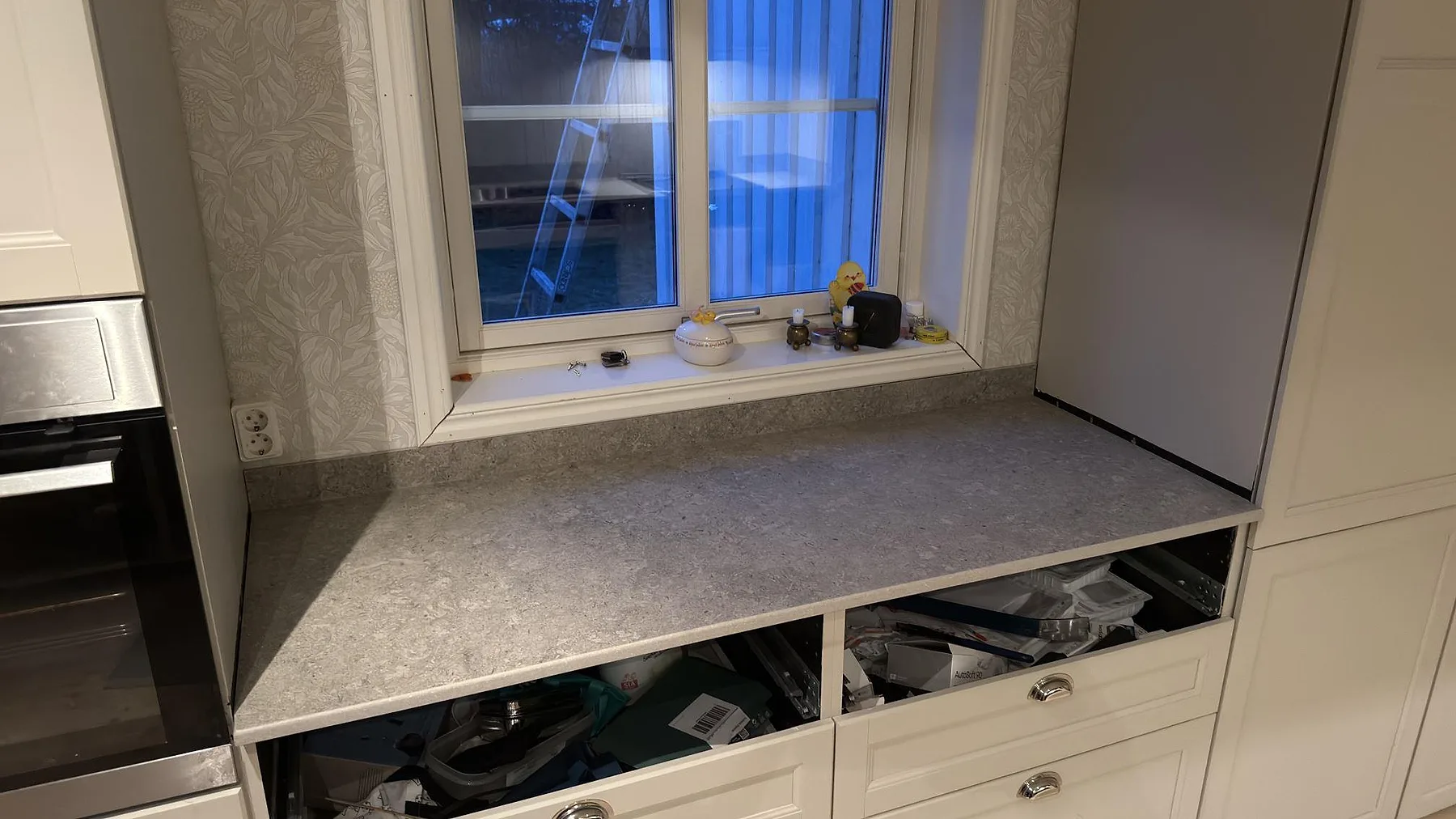 Fönsterbänk i matt grå Dekton VK03 Grigio keramik vid köksfönstret i ett kök i Charlottenberg.