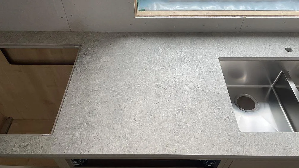 Köksbänkskiva i matt Dekton VK03 Grigio med hällöppning, diskho och grå arbetsyta i Fjärås.
