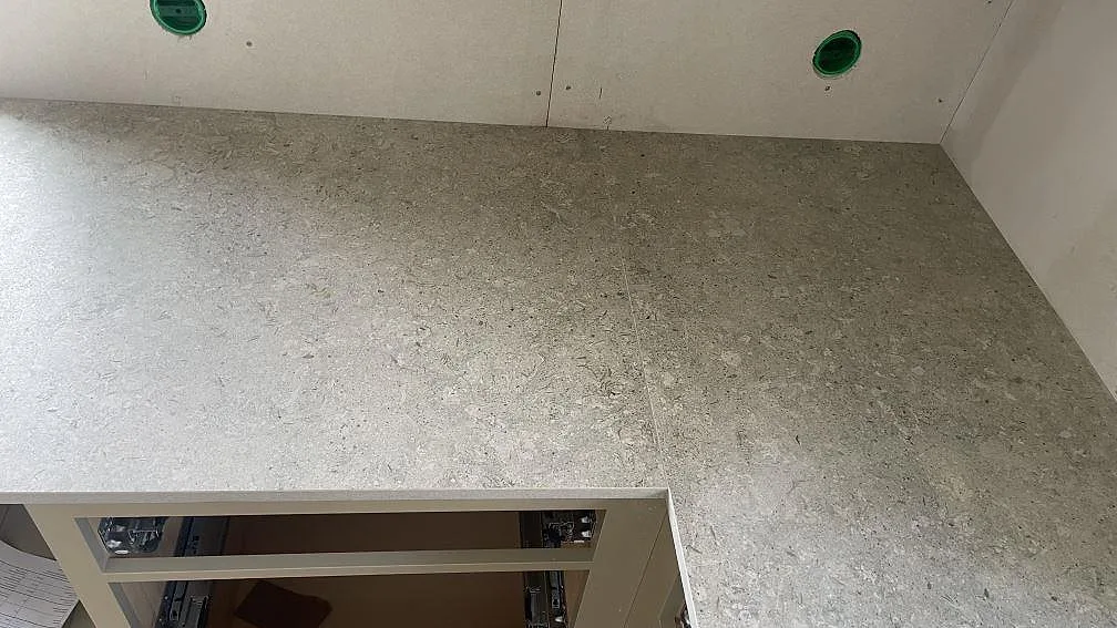 Hörnparti i matt Dekton VK03 Grigio med grå keramikyta och öppna köksstommar i Fjärås.
