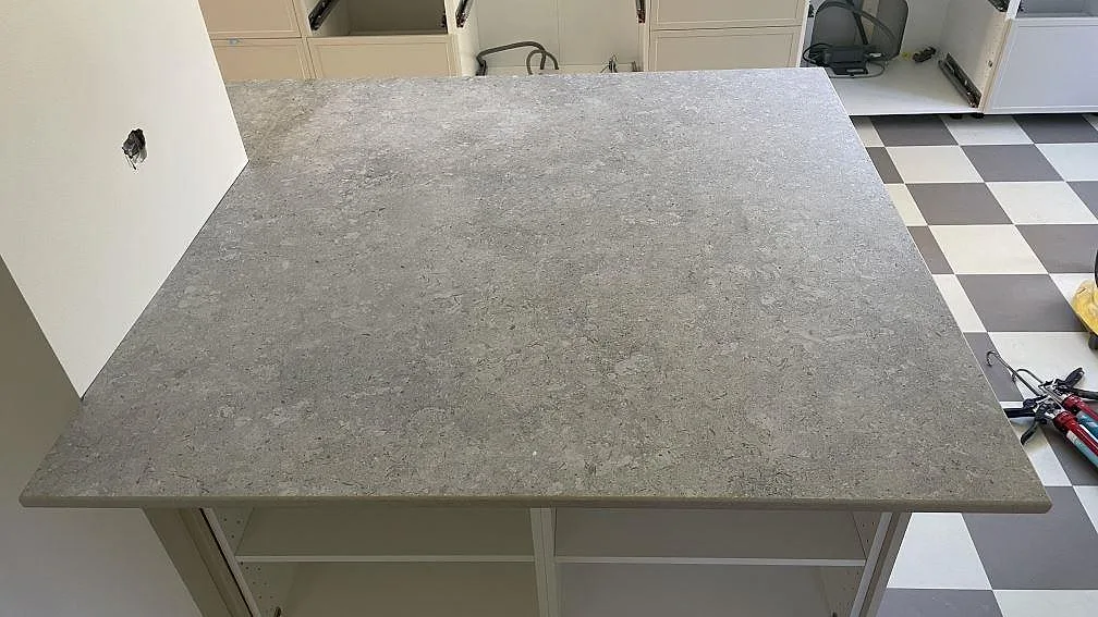Närbild på köksö i matt Dekton VK03 Grigio med spräcklig grå yta i ett kök i Kävlinge.