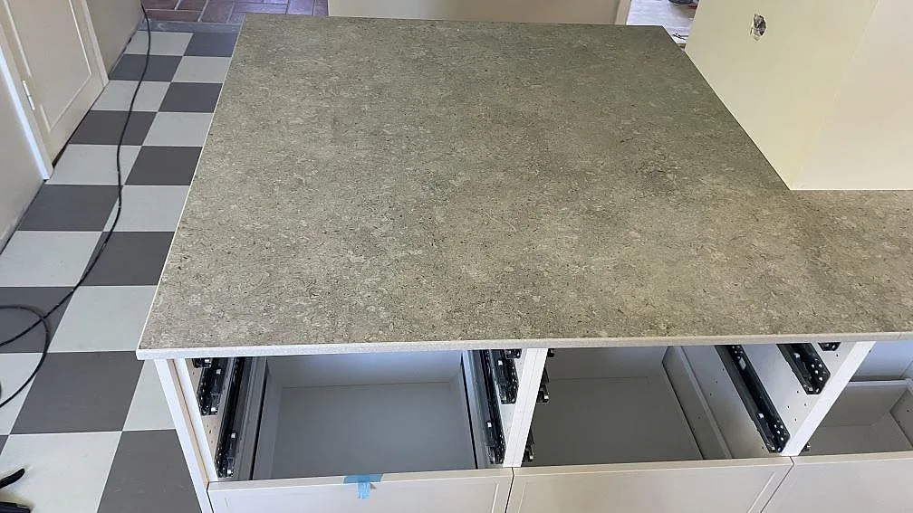 Köksö med öppen stomme och matt Dekton VK03 Grigio som bänkskiva i ett kök i Kävlinge.