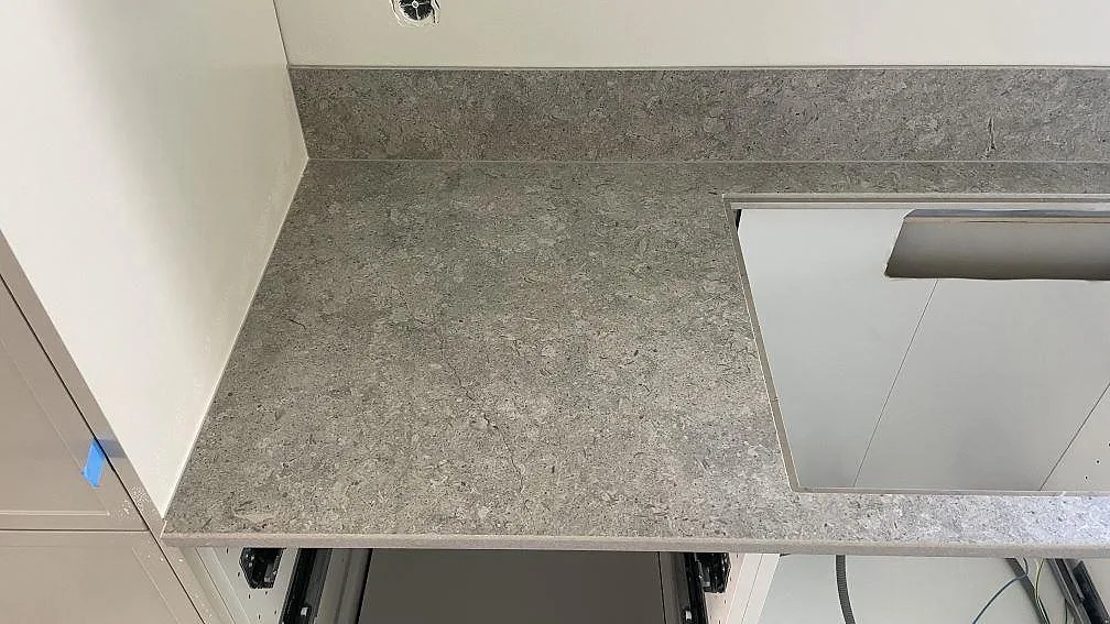 Bänkparti i matt Dekton VK03 Grigio med uppvikt stänkkant och öppna köksstommar i Kävlinge.