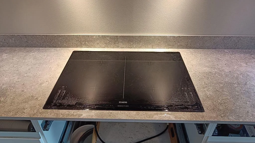 Induktionshäll monterad i matt Dekton VK03 Grigio med låg stänkkant i ett kök i Kullavik.