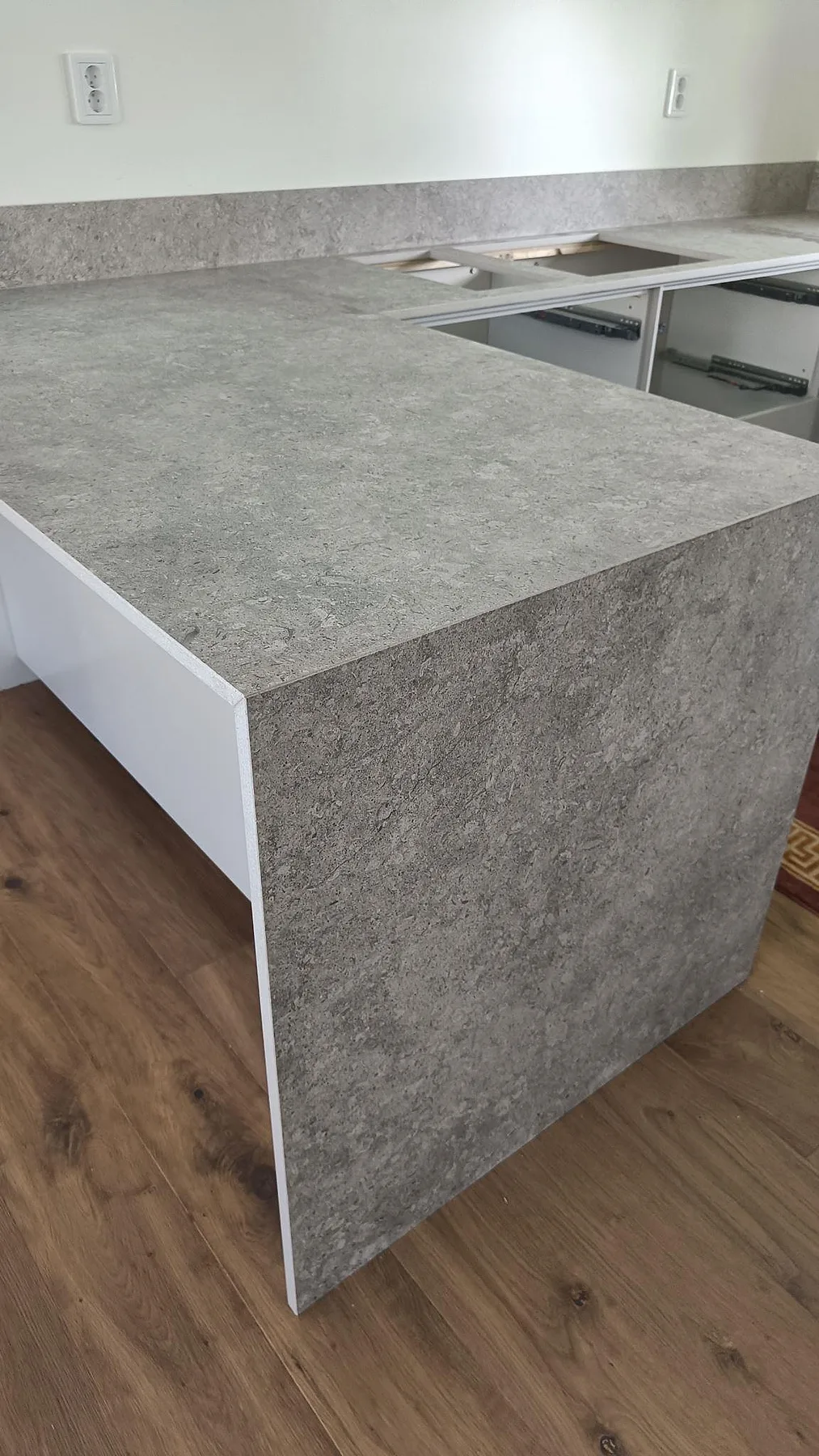 Matt köksbänkskiva i Dekton VK03 Grigio med matchande sidostycke och stänkkant under montering i Malmö.