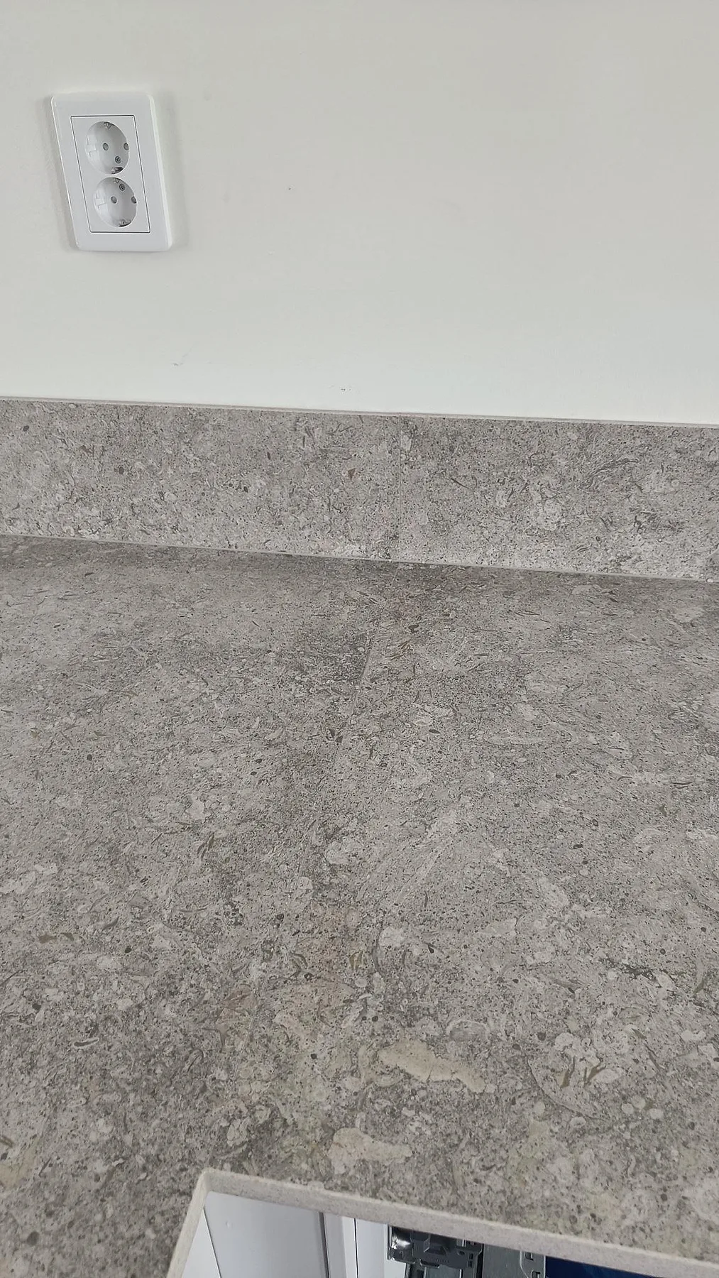 Ytdetalj av matt Dekton VK03 Grigio på köksbänk med låg stänkkant och eluttag ovanför i Malmö.