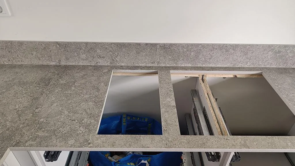 Detalj av köksbänkskiva i matt Dekton VK03 Grigio med stänkkant och urtag under montering i Malmö.
