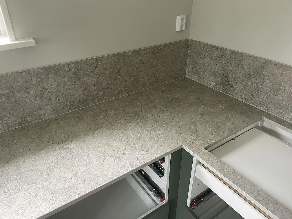 Hörndel med keramisk köksbänkskiva i matt Dekton VK03 Grigio och stänkskydd på väggarna i Stora Skedvi.