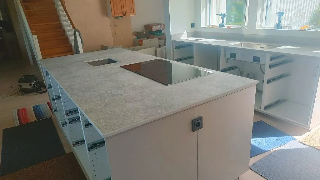 Köksbänkskiva i matt Dekton VK03 Grigio med svart häll och underlimmad rostfri diskho i ett kök i Torslanda.